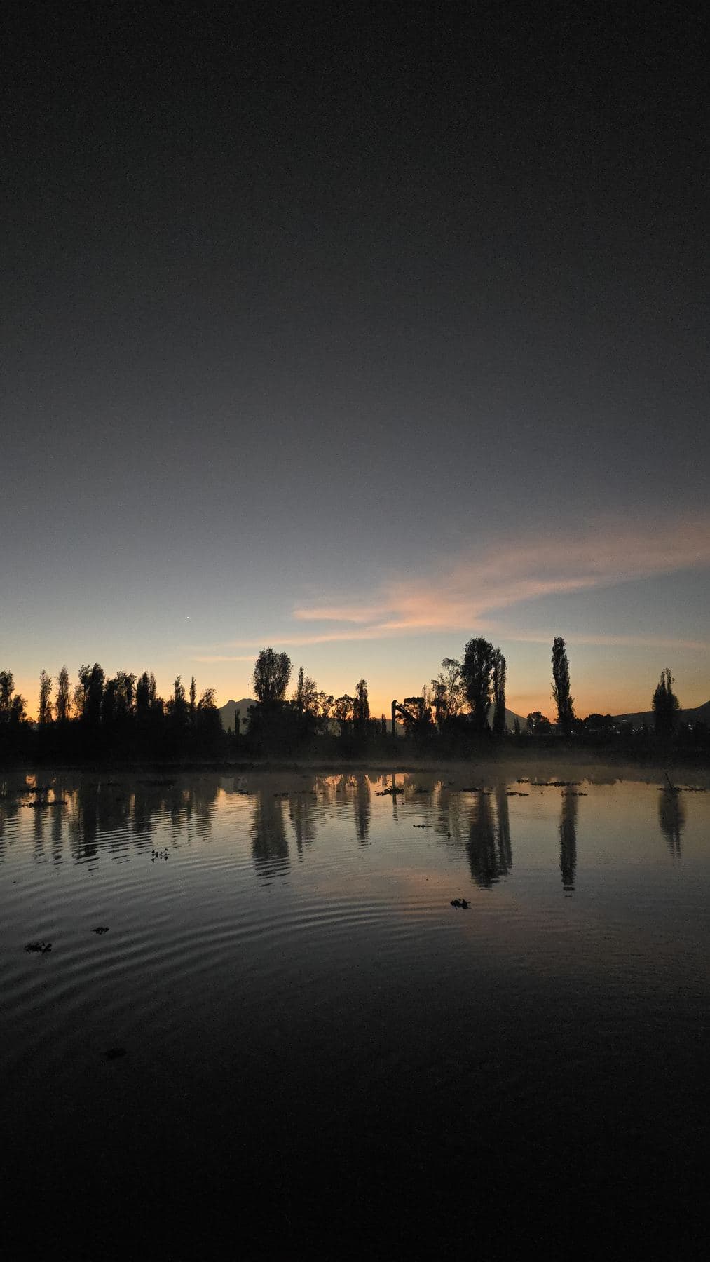 Primera luz del alba sobre el lago en calma